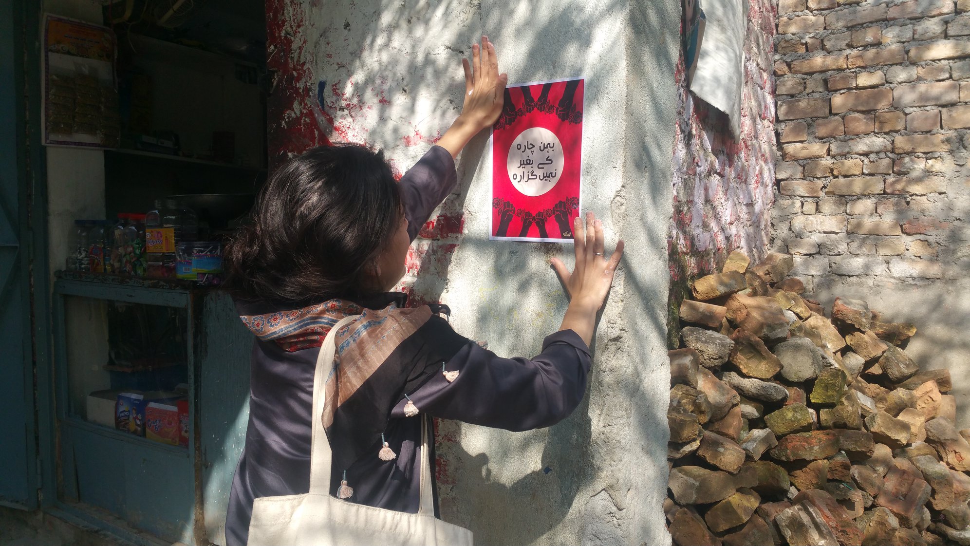 Pasting posters in neighbourhood shops across the city.